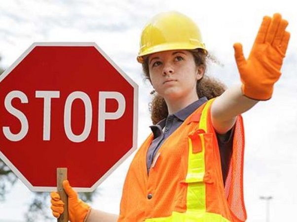 The girl with the stop sign and traffic control uniform 